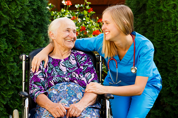 An image of an elderly person in a wheelchair with a care worker having a good time