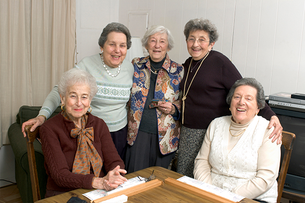 An image of five elderly people playing scrabble
